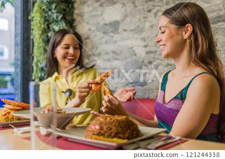 Women eating shrimps in ecuadorian restaurant in madrid Women eating shrimps in ecuadorian restaurant in madrid 121244338