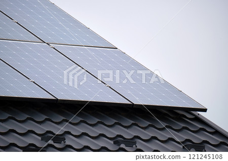 Private home roof covered with solar photovoltaic panels for generating of clean ecological electric energy in suburban rural town area. Concept of autonomous house 121245108