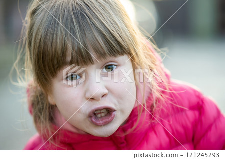 Portrait of a pretty child girl making amazed shoked expression on her face outdoors. 121245293