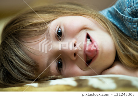 Portrait of a pretty child girl laying down at home. 121245303