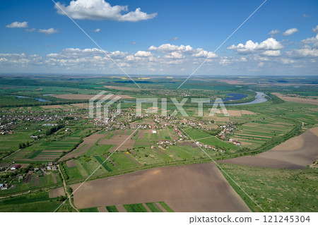 Plowed bare agricultural field with cultivated fertile soil prepared for seeding crops in spring season 121245304