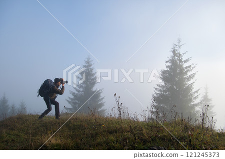 Photographer hiker taking picture of nature with digital camera Photographer hiker taking picture of nature with digital camera 121245373