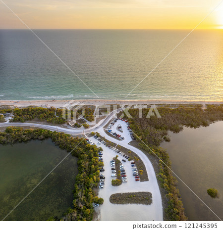 Parking lot at Florida Blind Pass beach on Manasota Key, USA. Vehicle parking area with cars parked on ocean beach parking lot. Summer vacation on beachfront Parking lot at Florida Blind Pass beach on Manasota Key, USA. Vehicle parking area with cars parked on ocean beach parking lot. Summer vacation on beachfront 121245395