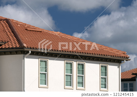 Overlapping rows of yellow ceramic roofing tiles covering residential building roof in southern Florida Overlapping rows of yellow ceramic roofing tiles covering residential building roof in southern Florida 121245415