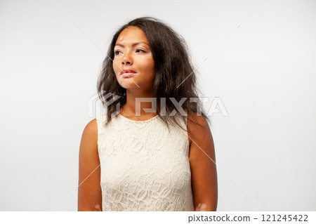 Thoughtful female fashion model standing against Thoughtful female fashion model standing against 121245422