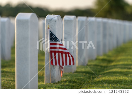Military burial headstones. Sarasota National Cemetery with rows of white tomb stones and USA flags on green grass. Memorial Day concept 121245532