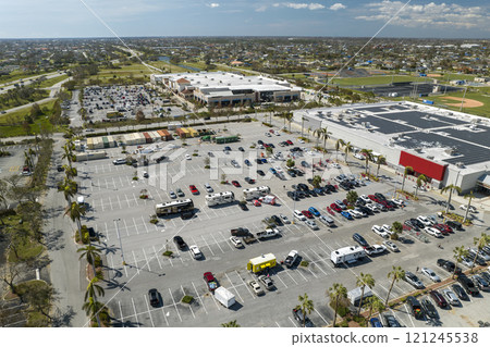 Many parked cars on store parking lot with lines and markings for parking places and directions. Place for vehicles in front of a shopping mall center Many parked cars on store parking lot with lines and markings for parking places and directions. Place for vehicles in front of a shopping mall center 121245538