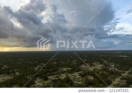 Landscape of dark ominous clouds forming on stormy sky during heavy thunderstorm over rural town area at sunset Landscape of dark ominous clouds forming on stormy sky during heavy thunderstorm over rural town area at sunset 121245581