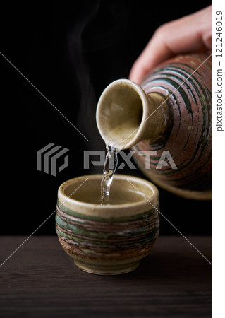 Pour hot sake into the sake cup 121246019
