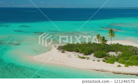 Aerial view of a beautiful tropical island with turquoise water and white sand, featuring a woman enjoying her holiday near the holiday writing on the beach Aerial view of a beautiful tropical island with turquoise water and white sand, featuring a woman enjoying her holiday near the holiday writing on the beach 121246570