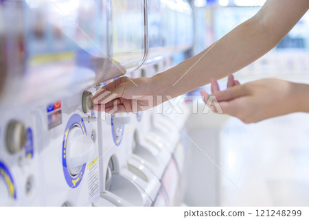 年輕女子旋轉膠囊玩具扭蛋修剪完畢 年輕女子旋轉膠囊玩具扭蛋修剪完畢 121248299