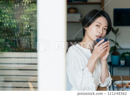 A woman drinking coffee 121248362