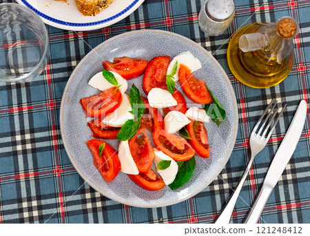 Refreshing Caprese salad of tender mozzarella and ripe tomatoes. Italian style appetizer or entree 121248412