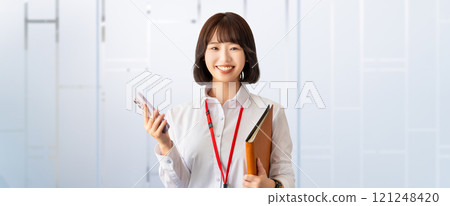 Smiling young woman/businesswoman holding a smartphone Smiling young woman/businesswoman holding a smartphone 121248420