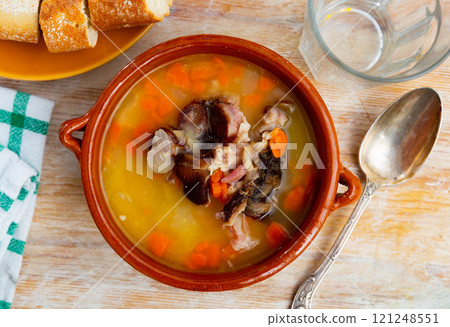 Fragrant pea soup with smoked meats and vegetables in plate Fragrant pea soup with smoked meats and vegetables in plate 121248551