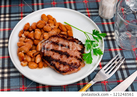 Plate contains light side dish of stewed vegetables - red kidney beans with meat patty Plate contains light side dish of stewed vegetables - red kidney beans with meat patty 121248561