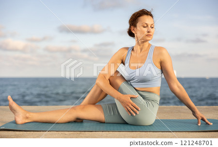 Yoga practice on embankment, female athlete fulfil carry out wakrasana 121248701