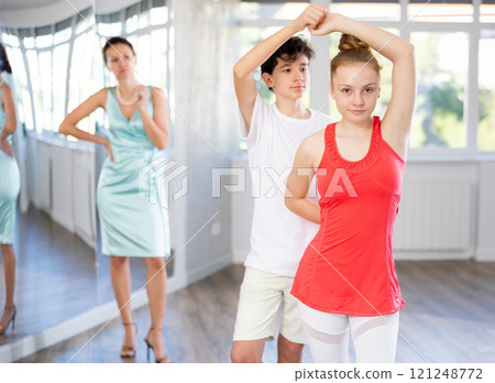Teenage boy and girl performing waltz in pair during dance lesson 121248772
