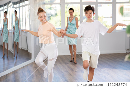 Cheerful teenage girl and boy rehearsing jive dance moves as couple 121248774