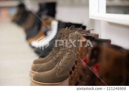 Women's boots displayed on counter in store 121248908