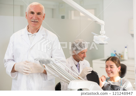 Senior man doctor is standing in dental office, clinic Senior man doctor is standing in dental office, clinic 121248947