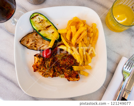 Chicken and potatoes served with vegetables 121249077