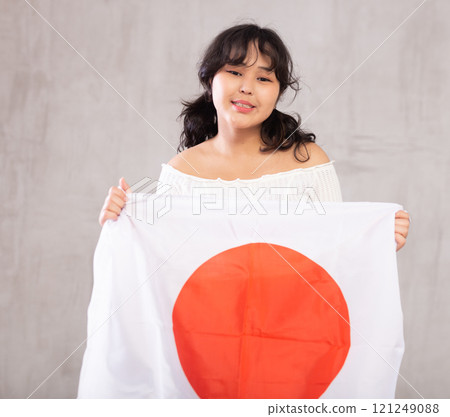 Smiling young girl holding Japan flag 121249088