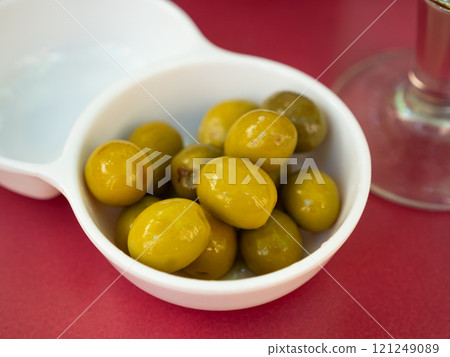 Green olives with pits served in bowl 121249089