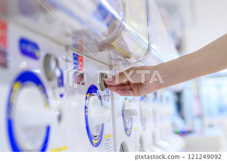 Young woman spinning a capsule toy, gacha, trimmed up 121249092