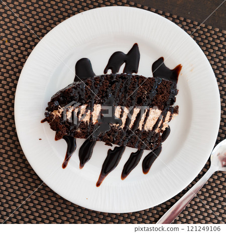 Piece of dark chocolate cake with topping Piece of dark chocolate cake with topping 121249106