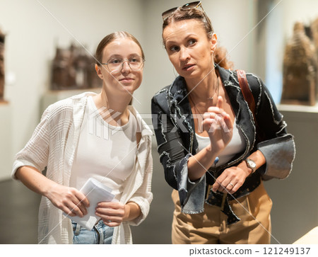 Woman and teenage girl looking at sculpture hall 121249137