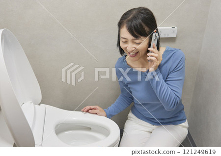 一名女子在浴室裡打電話給修理工 121249619