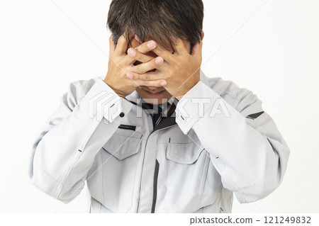 一個穿著工作服的男人抱著頭，白色背景 121249832