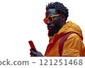 A man in sunglasses and orange jacket checks his phone 121251468