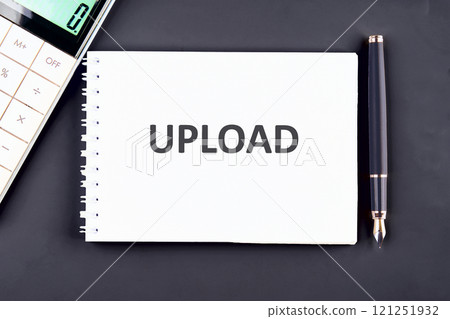 Notepad with upload text beside calculator and fountain pen on dark background Notepad with upload text beside calculator and fountain pen on dark background 121251932