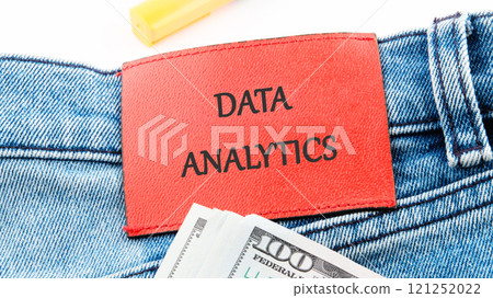 The concept of technology and development. Phrase, words, text DATA ANALYTICS on the leather label of jeans 121252022