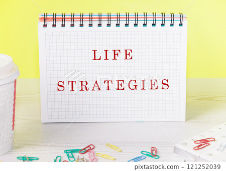 The concept of business and development. The conceptual inscription of LIFE STRATEGIES written in a notebook on a yellow background The concept of business and development. The conceptual inscription of LIFE STRATEGIES written in a notebook on a yellow background 121252039
