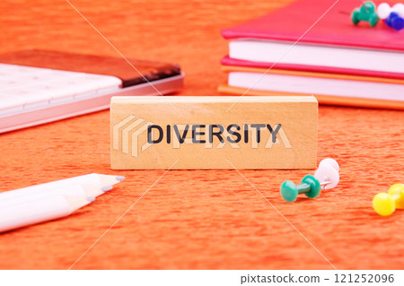 Business concept. The conceptual phrase DIVERSITY written through wooden blocks on an orange background Business concept. The conceptual phrase DIVERSITY written through wooden blocks on an orange background 121252096