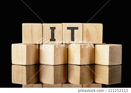 Information technology. IT abbreviation made of wooden cubes on a black background 121252113