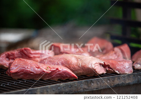 Indulge in Delicious Cuts of Meat Grilling Over an Open Flame for a Savory Experience 121252408