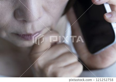 Elderly woman receiving a spoofed phone call on her smartphone Elderly woman receiving a spoofed phone call on her smartphone 121252758