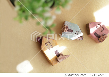 A cute little miniature house placed by a window where light shines in A cute little miniature house placed by a window where light shines in 121252759