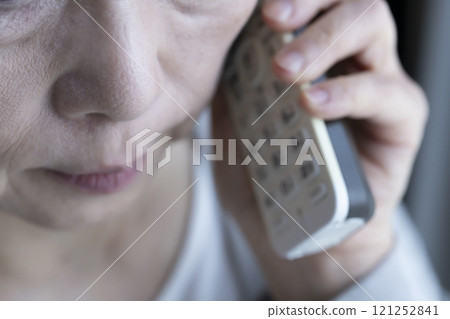 Elderly woman receiving spoofed phone call, landline, home appliances 121252841