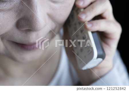 Elderly woman receiving spoofed phone call, landline, home appliances 121252842