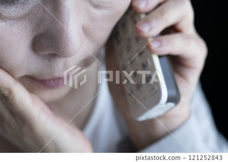 Elderly woman receiving spoofed phone call, landline, home appliances Elderly woman receiving spoofed phone call, landline, home appliances 121252843