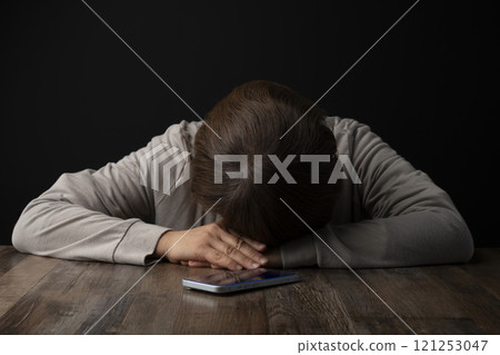 一位女士將頭放在智慧型手機上 121253047