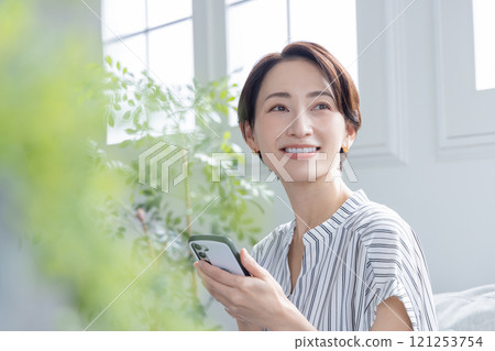 A woman watching a smartphone 121253754