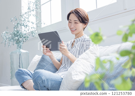A woman looking at her smartphone in the living room 121253780