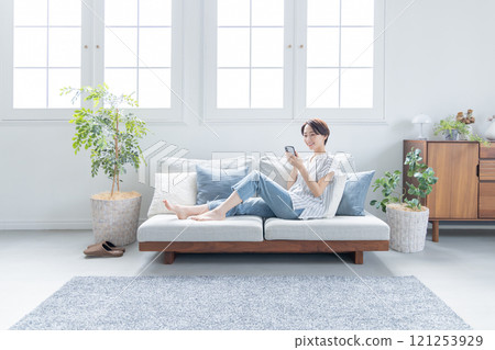 A woman looking at her smartphone in the living room A woman looking at her smartphone in the living room 121253929