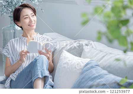 A woman reading a book in the living room A woman reading a book in the living room 121253977